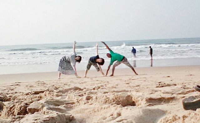 インドのビーチでヨガ仲間とポーズ
